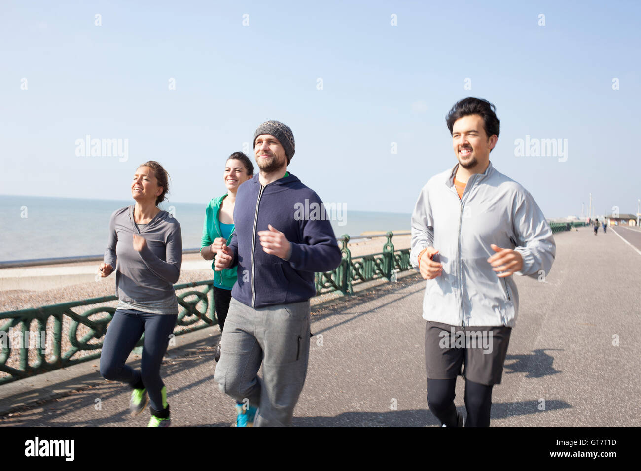 Male and female runners running together at Brighton beach Stock Photo