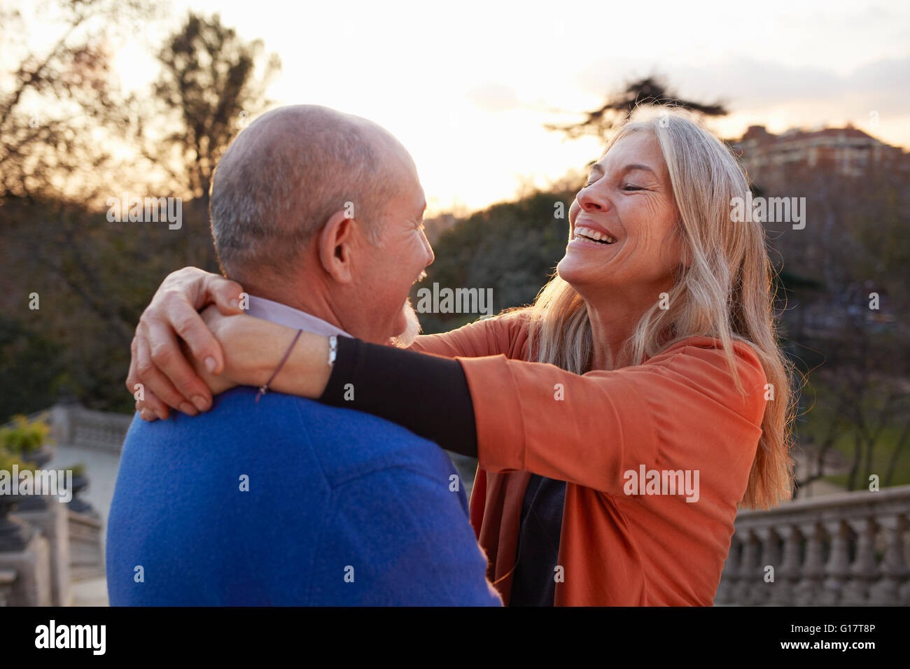 Woman with arms around man face to face smiling Stock Photo