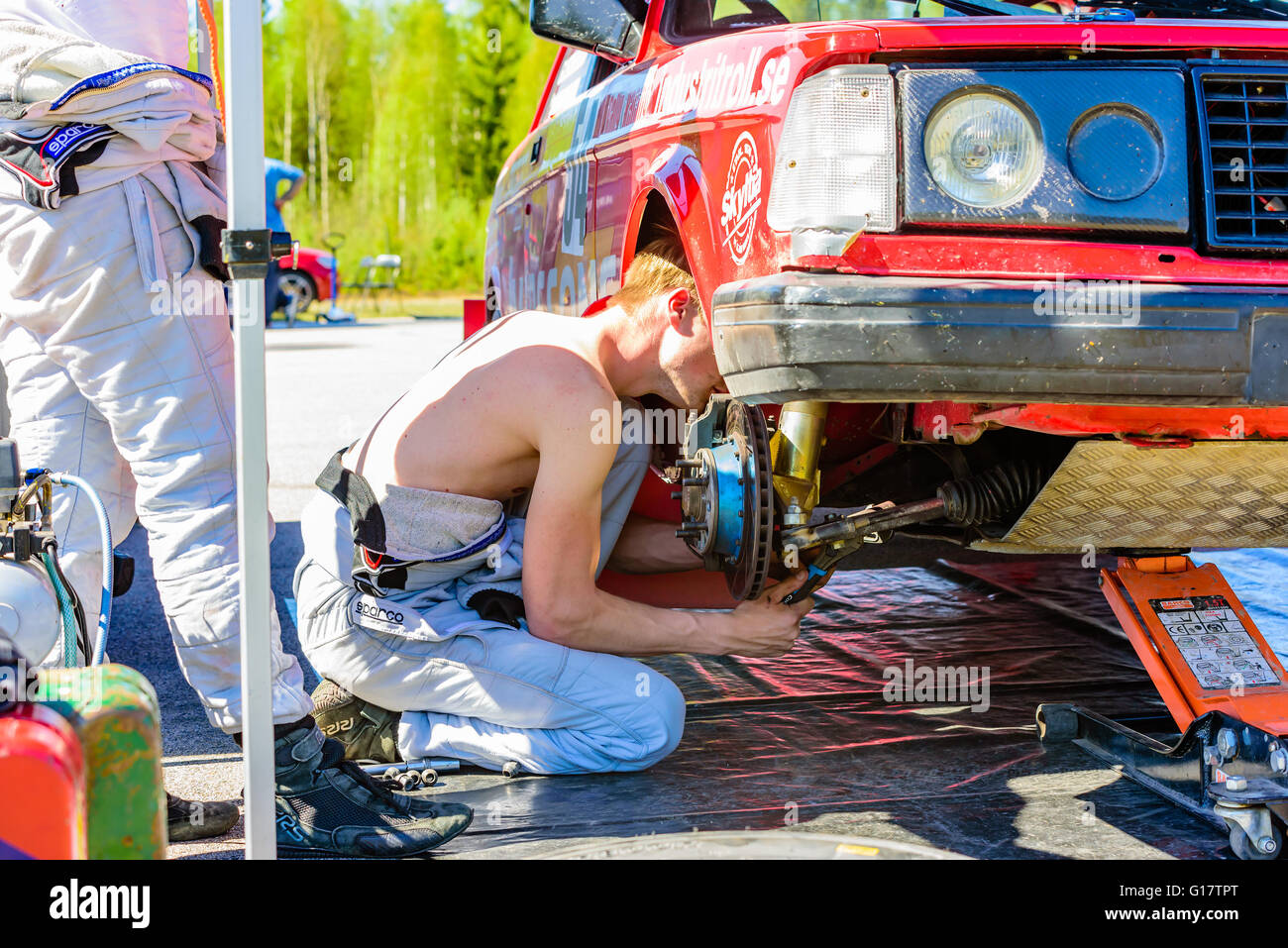 Emmaboda, Sweden - May 7, 2016: 41st South Swedish Rally in service depot. Crew working under the front wheelhouse at team Alenm Stock Photo