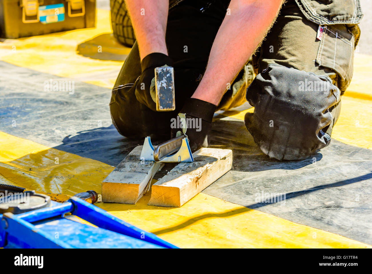 Emmaboda, Sweden - May 7, 2016: 41st South Swedish Rally in service depot. Crew adjusting a clamp with a wrench and a hammer clo Stock Photo