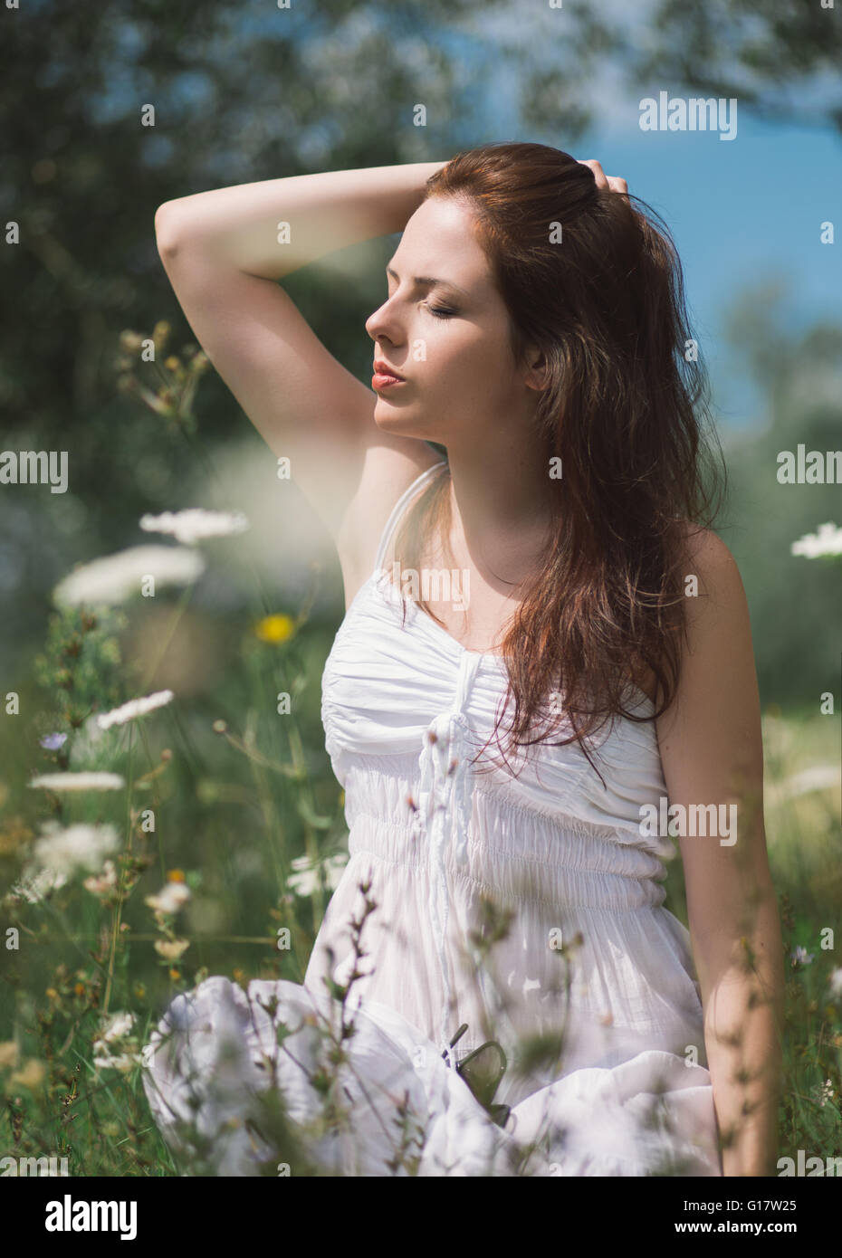 Young woman in white dress enjoying the sun Stock Photo - Alamy