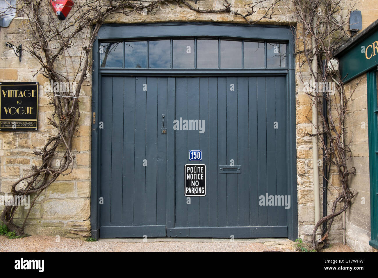 Polite Notice No Parking sign on garage doors  on The Hill on the A361 through Burford, Oxfordshire, UK Stock Photo