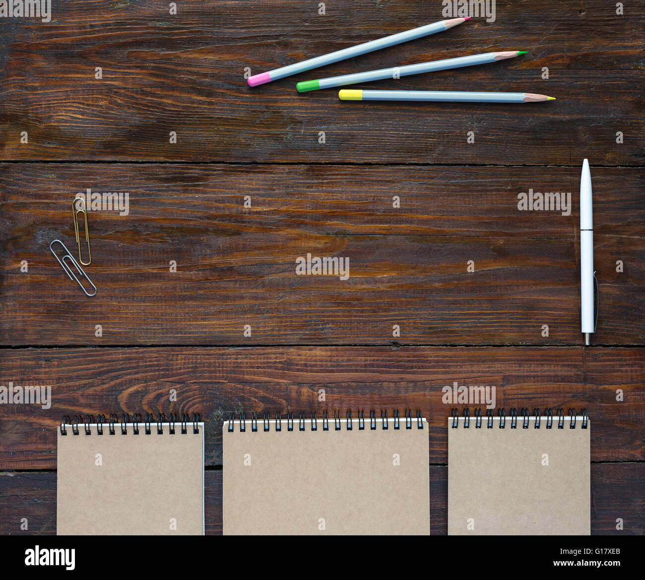 Dark Brown Wooden Desk with Sketchbooks and Pencils Stock Photo