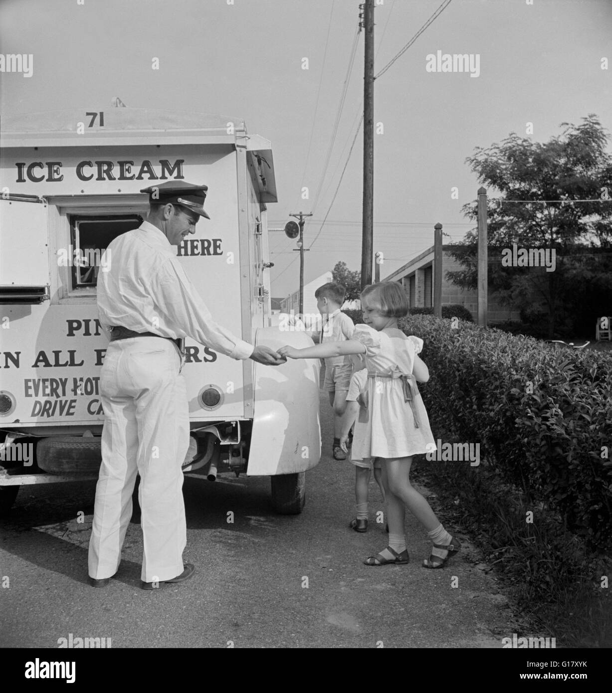 Young Girl Buying Ice Cream from Good Humor Man at Federal Housing Project, Greenbelt, Maryland, USA, Marjorie Collins for Farm Security Administration, June 1942 Stock Photo