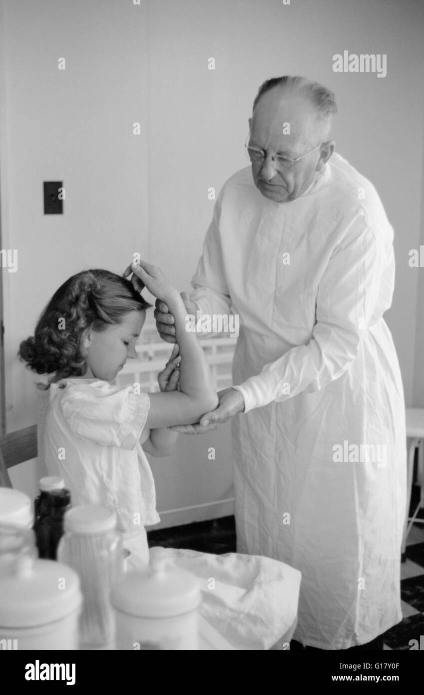 Doctor Examines Young Girl's Fractured Arm, Farm Security Administration (FSA) Camp Clinic, Weslaco, Texas, USA, Arthur Rothstein for Farm Security Administration, February 1942 Stock Photo