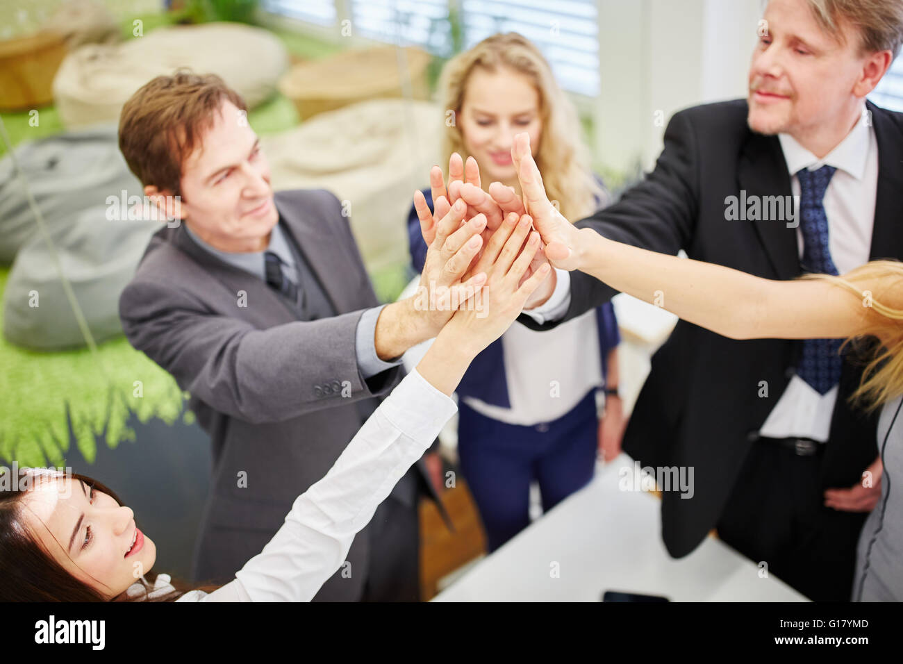 Business people give each other a high five in the office for the ...
