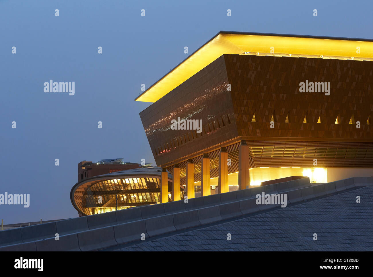 Corner elevation of lit up Incubator building. Masdar City, Masdar City, United Arab Emirates. Architect: various, 2014. Stock Photo