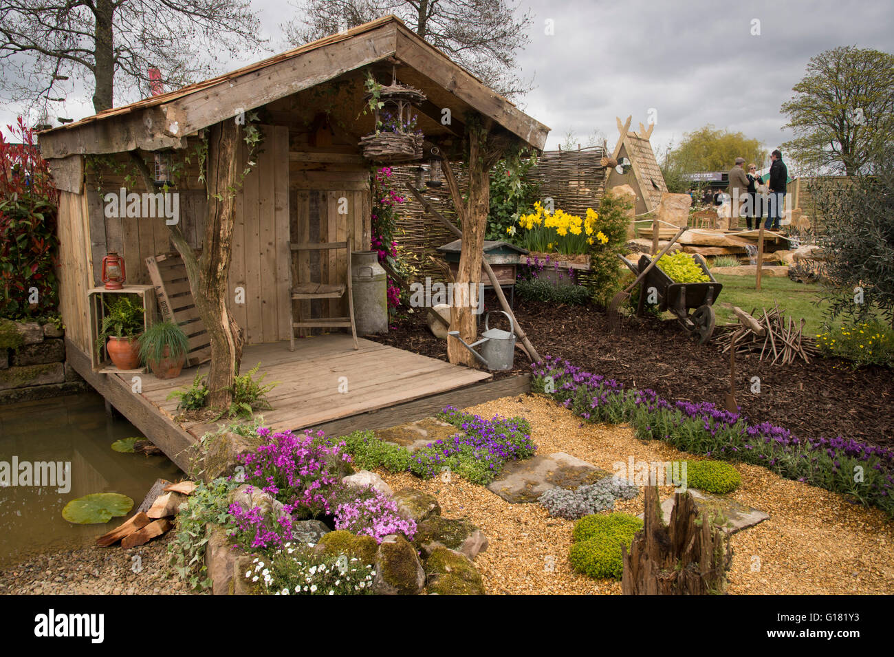 Harrogate Spring Flower Show 2016 (North Yorkshire, England) - rustic shelter, decking, pond and plants in the Wildlife Paradise' show garden. Stock Photo