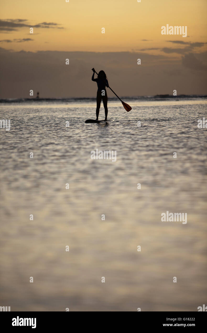 Woman leisurely paddling stand up board at Ala Moana Beach Park at