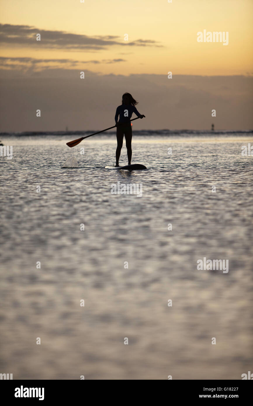 Woman leisurely paddling stand up board at Ala Moana Beach Park at