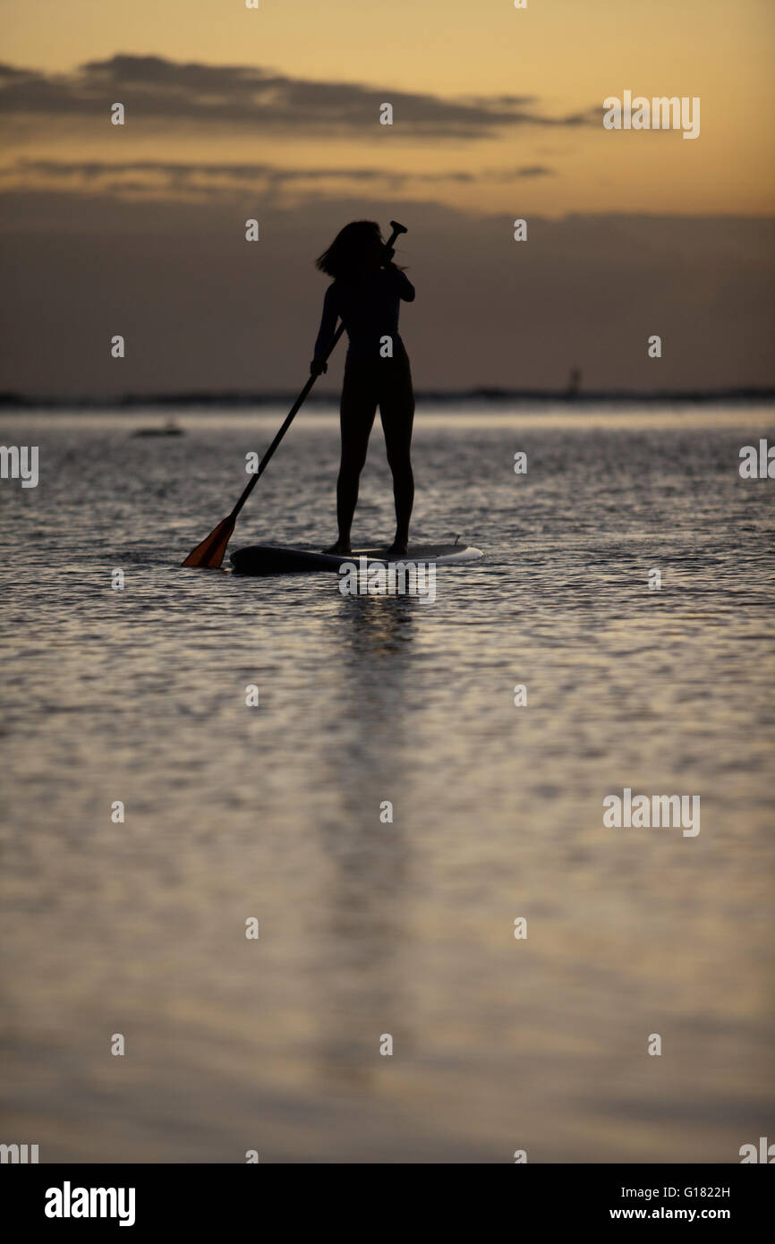 Woman leisurely paddling stand up board at Ala Moana Beach Park at