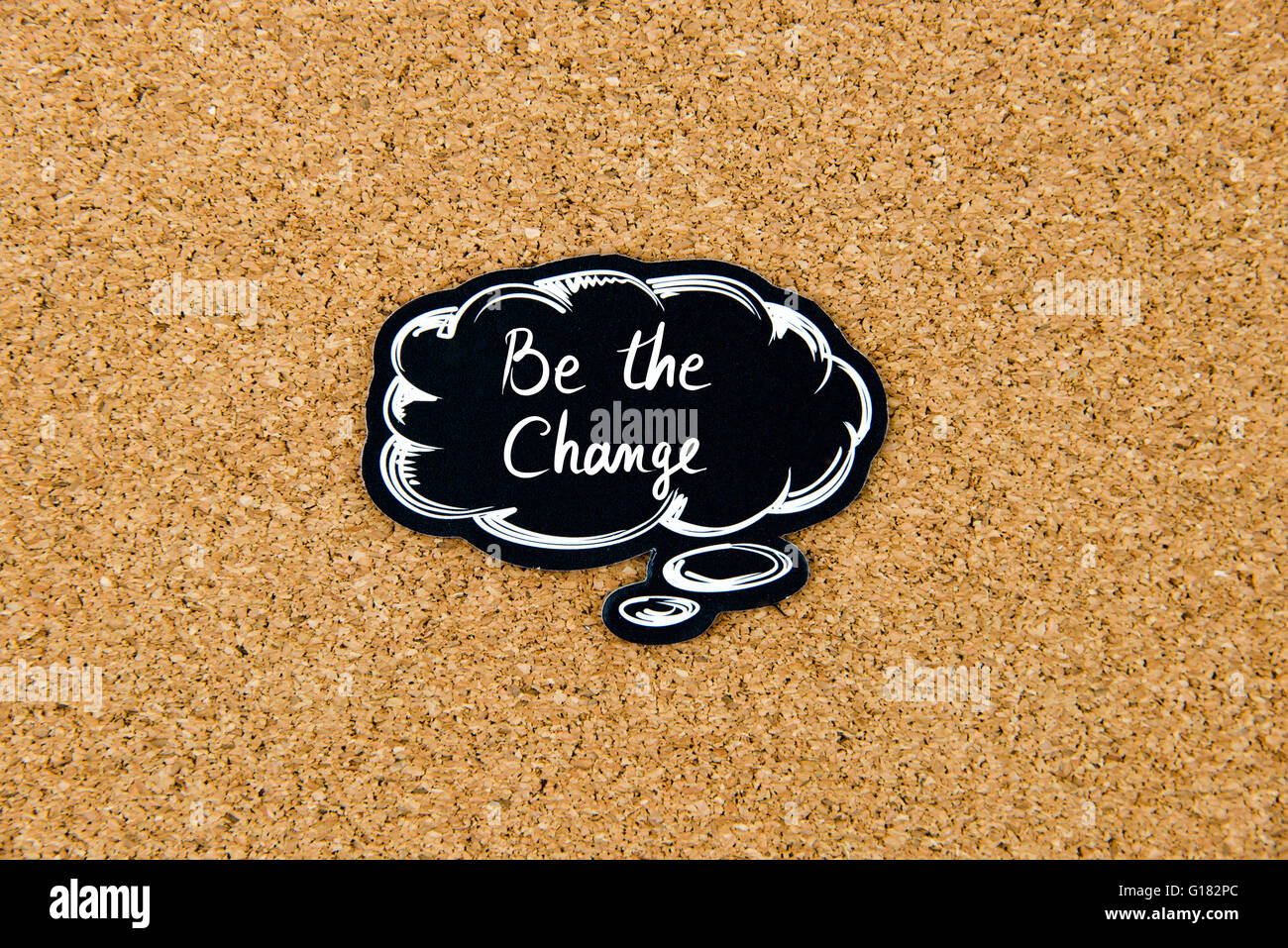 Be The Change written on black thinking bubble over cork board background, copy space available Stock Photo