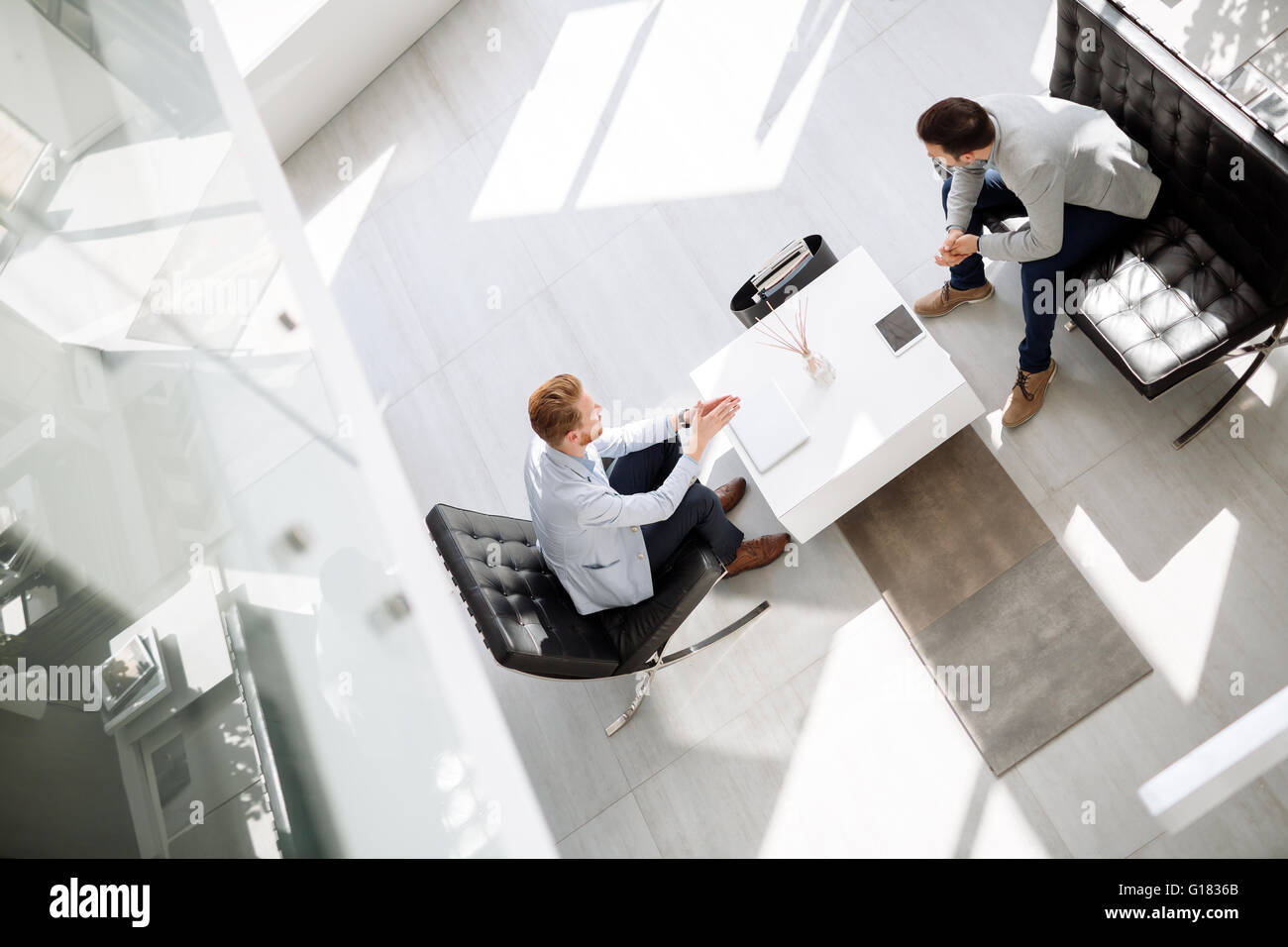 Business people discussing ideas in office lobby Stock Photo