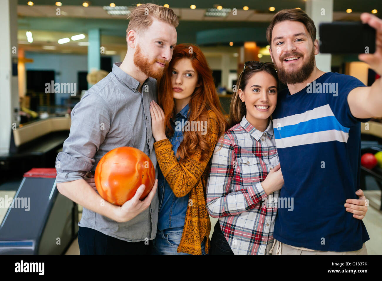 Friends taking selfies of themselves bowling Stock Photo