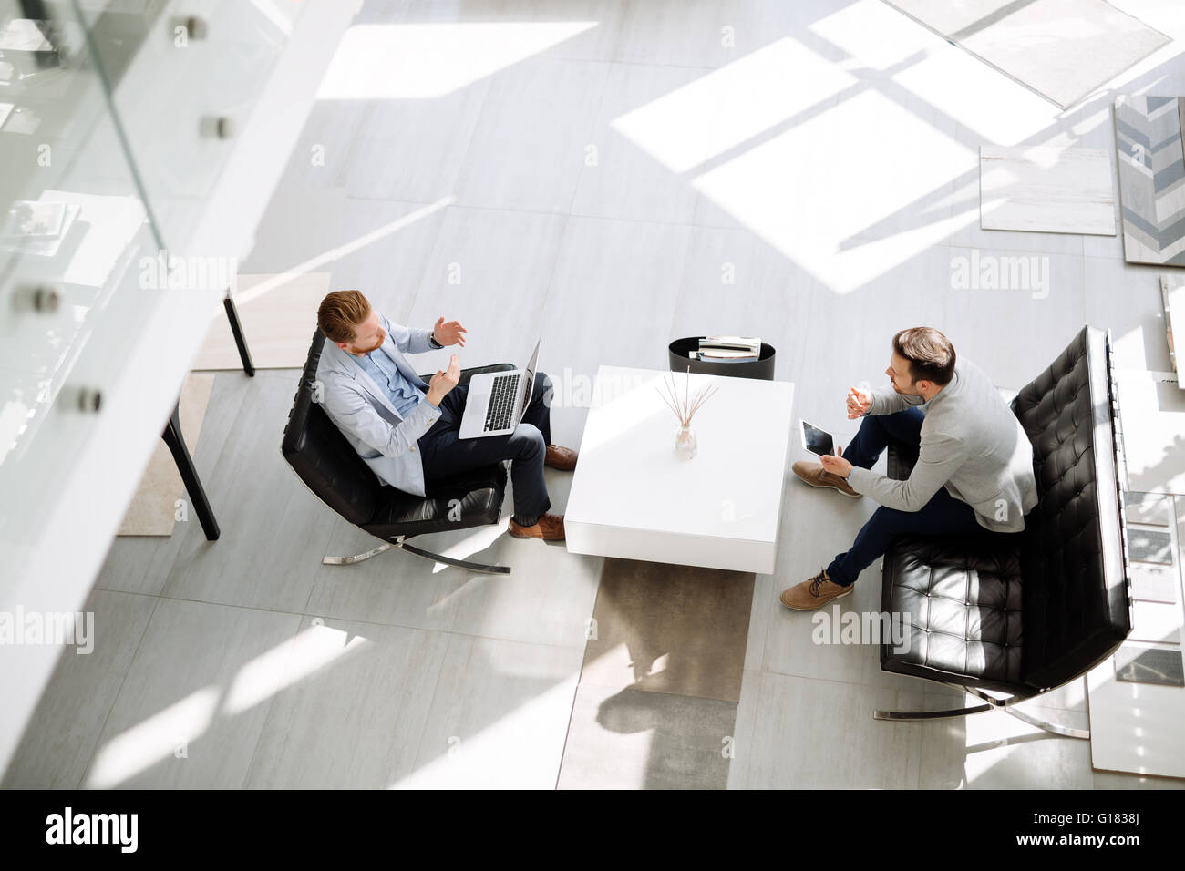 Business people discussing ideas in office lobby Stock Photo