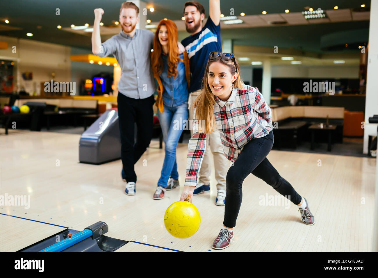 Friends having great time playing bowling and laughing Stock Photo