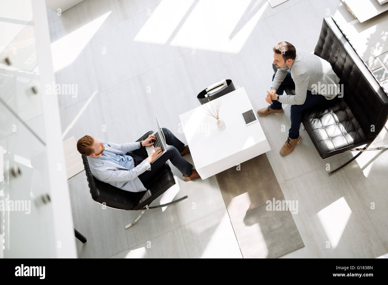 Business people discussing ideas in office lobby Stock Photo