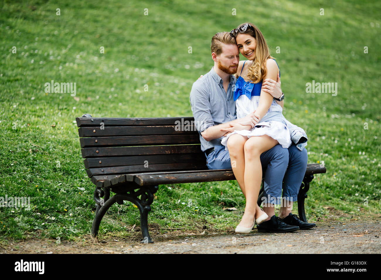 Romantic couple in love sitting on park bench Stock Photo - Alamy