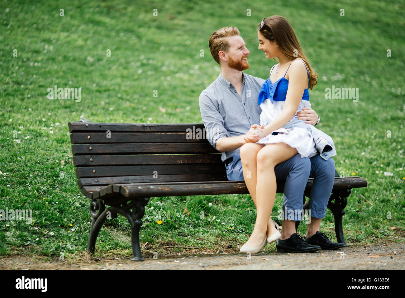 Romantic couple in park sitting on bench Stock Photo - Alamy