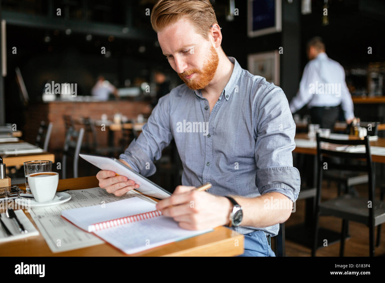 Businessman taking notes in cafe and writing down ideas Stock Photo