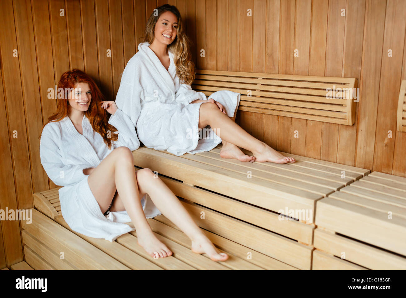 Beautiful women enjoying sauna treatment in bathrobes Stock Photo