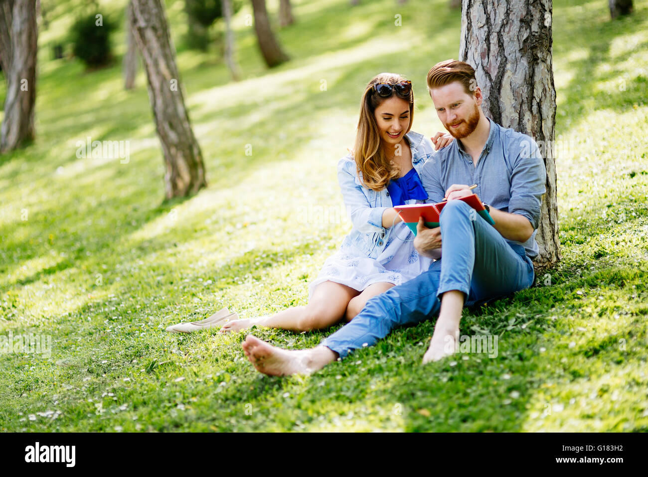 Lovely university students studying outdoors in park Stock Photo - Alamy
