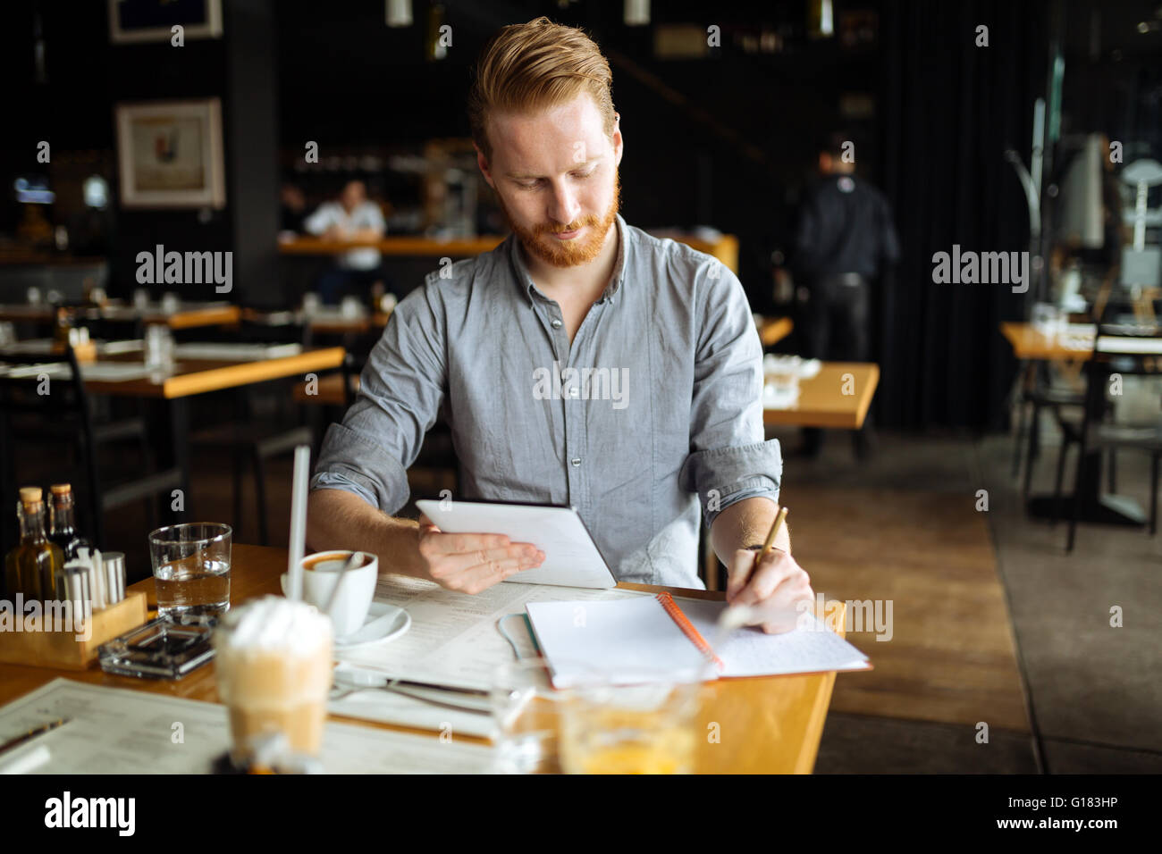 Businessman taking notes and writing down new ideas in cafe during break Stock Photo