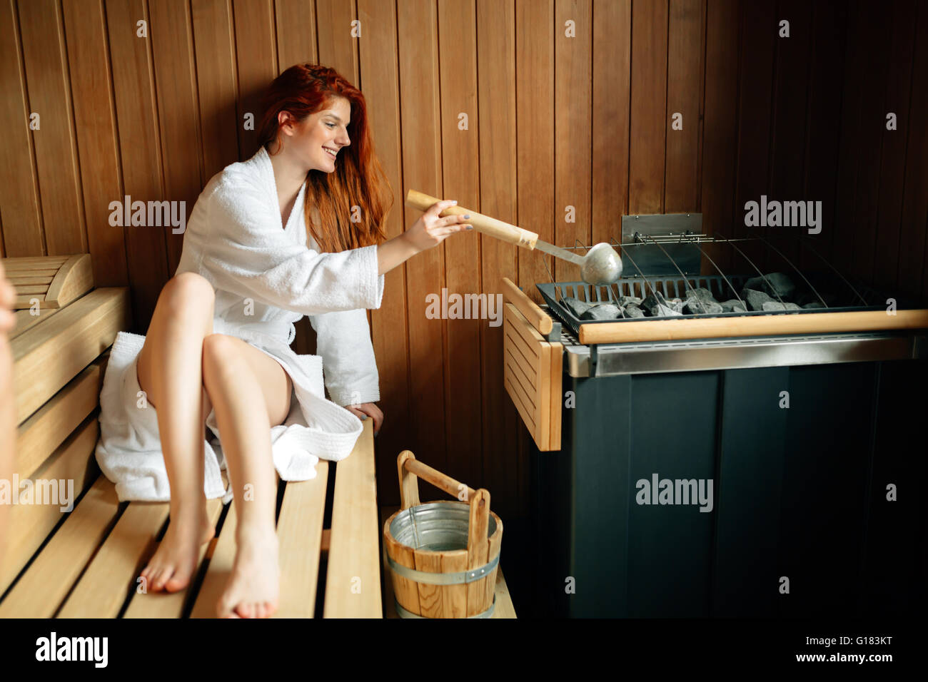 Beautiful woman in bathrobe  relaxing in finnish sauna Stock Photo