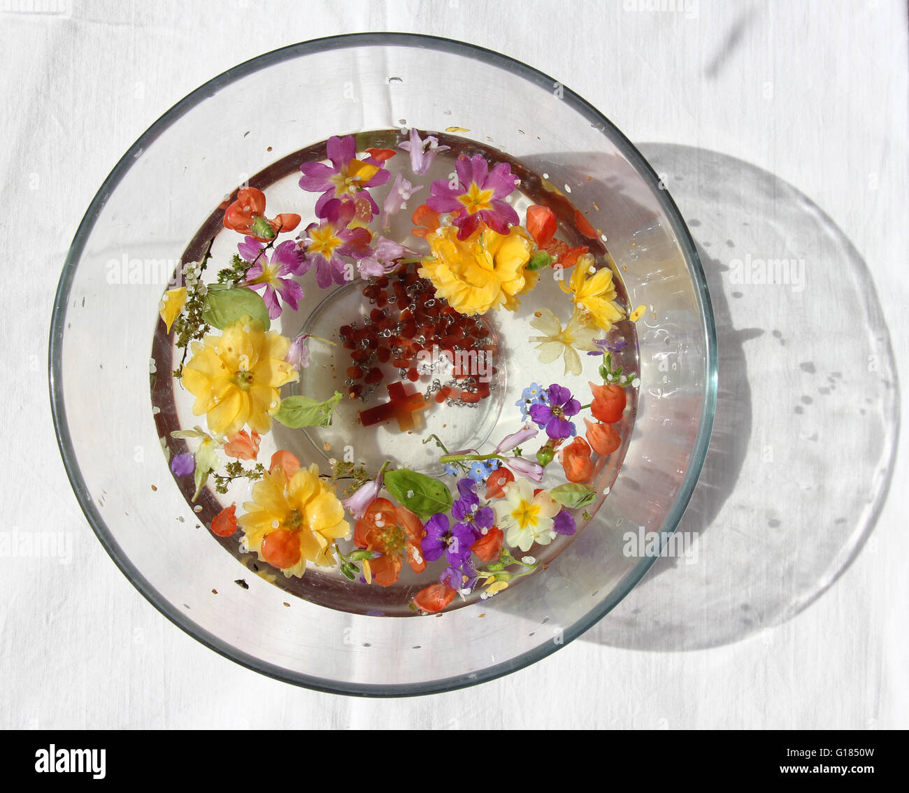 catholic rosary in bowl of flower petals, celebrating ascension of Jesus Stock Photo