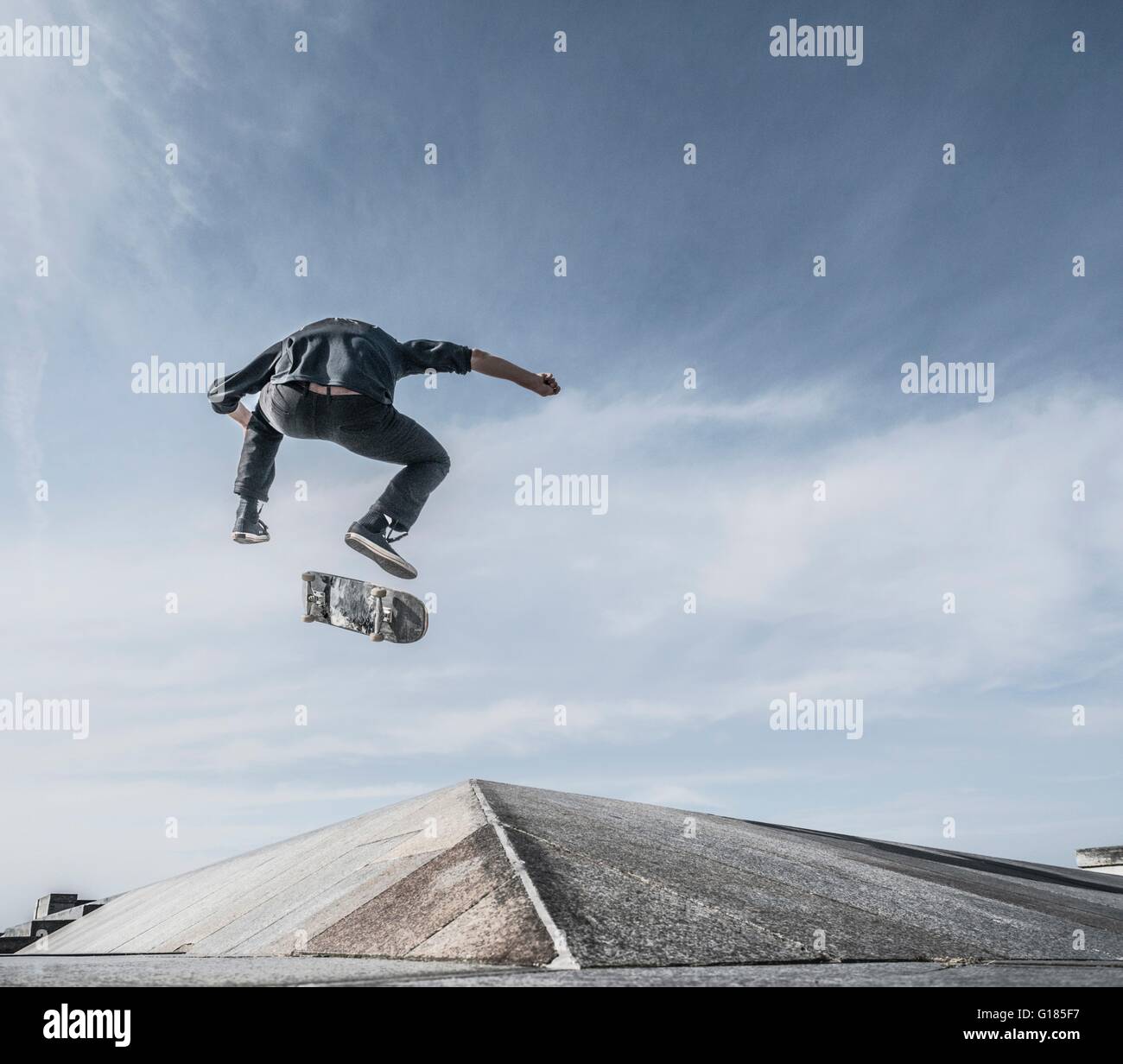 Young man skateboarding on roof Stock Photo