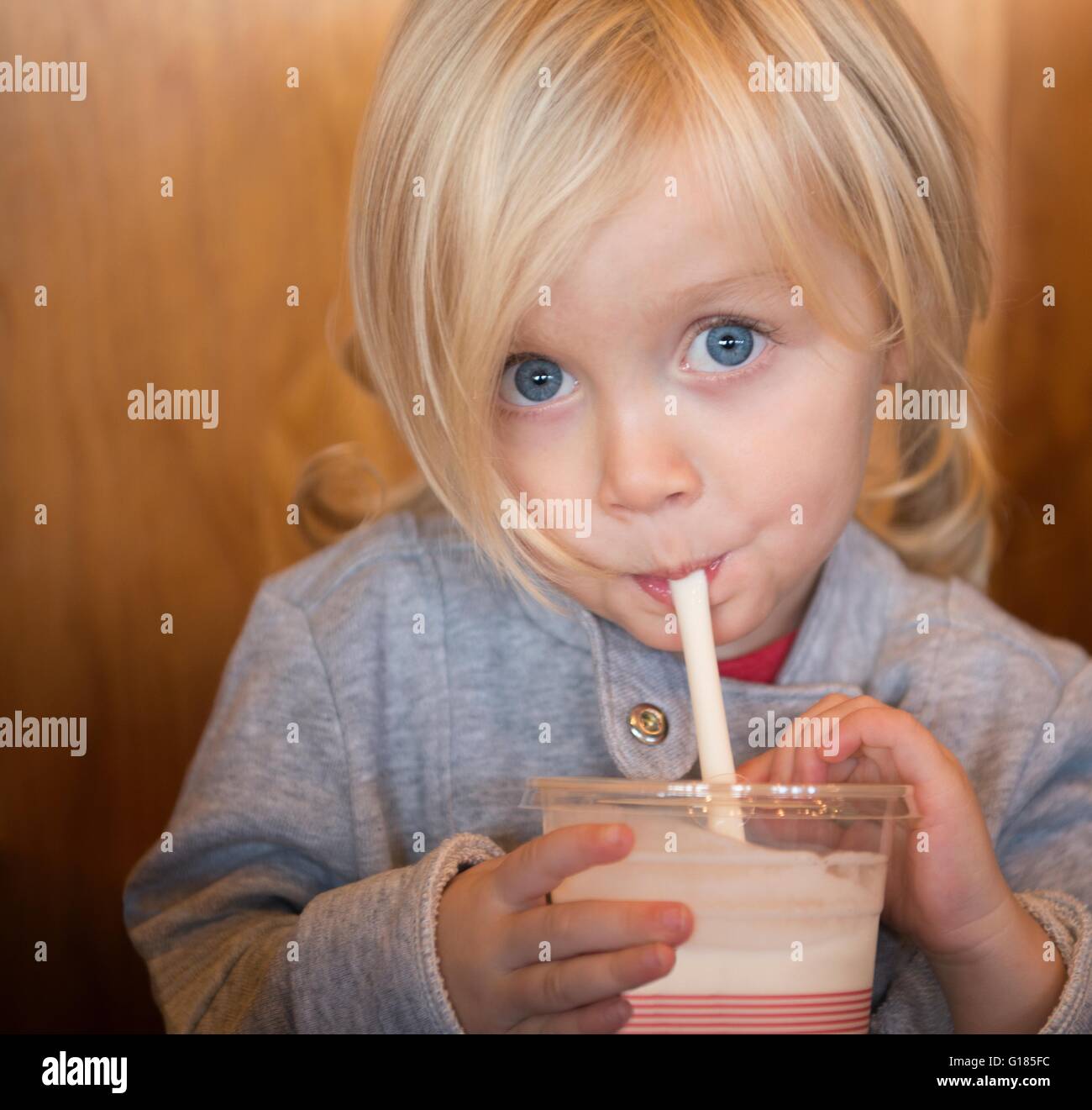 Toddler drinking with straw Stock Photo