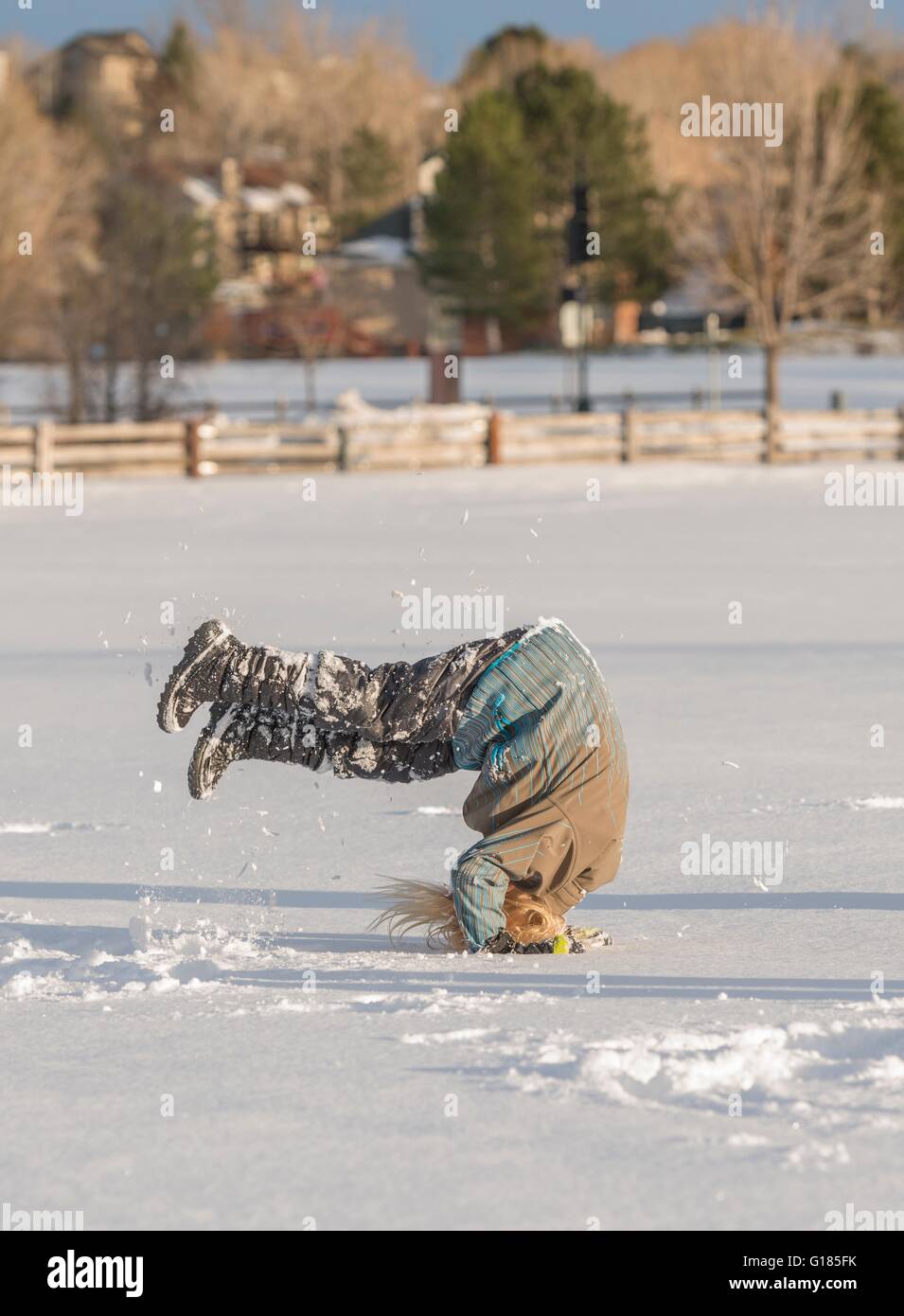 Child doing somersault in snow Stock Photo