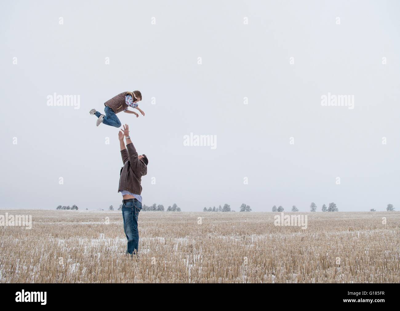 Parent throwing child in air Stock Photo Alamy