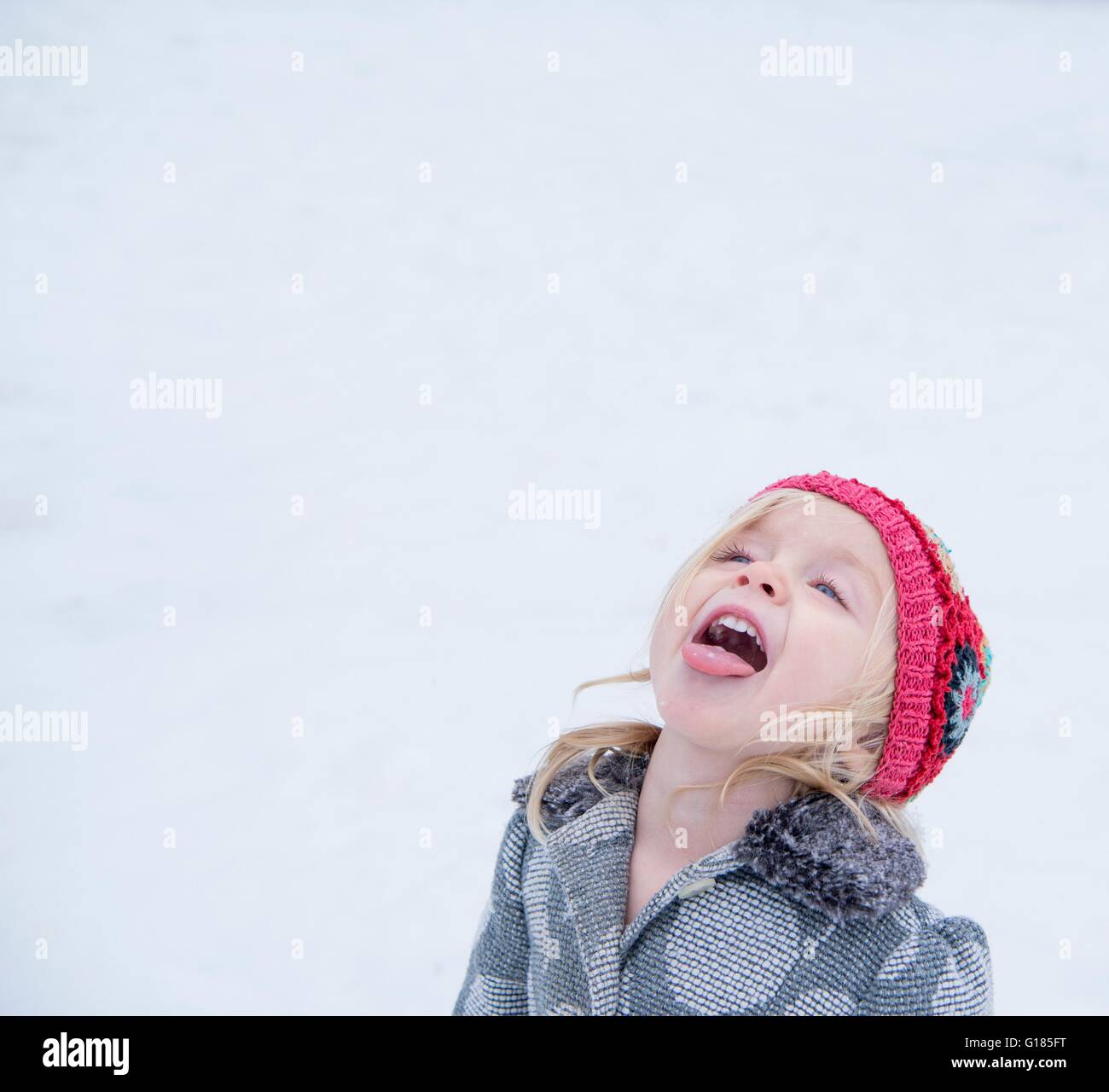 Toddler sticking out tongue to taste snow Stock Photo