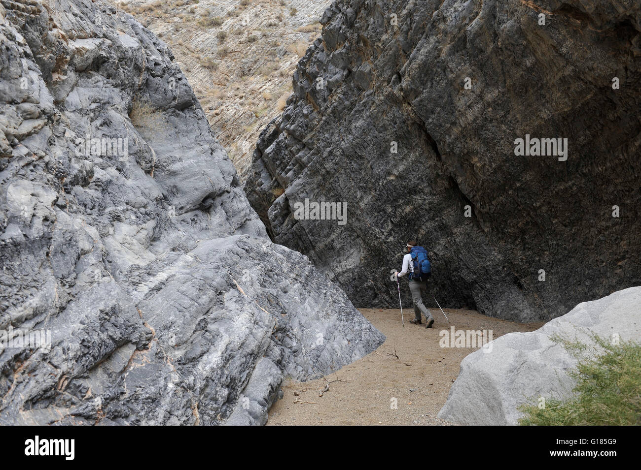 Hiker exploring rock formations, Marble Canyon, Death Valley National Park, California Stock Photo