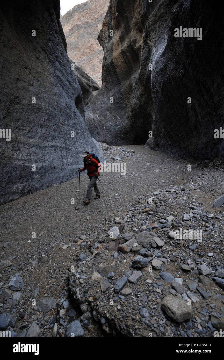 Hiker exploring rock formations, Marble Canyon, Death Valley National Park, California Stock Photo