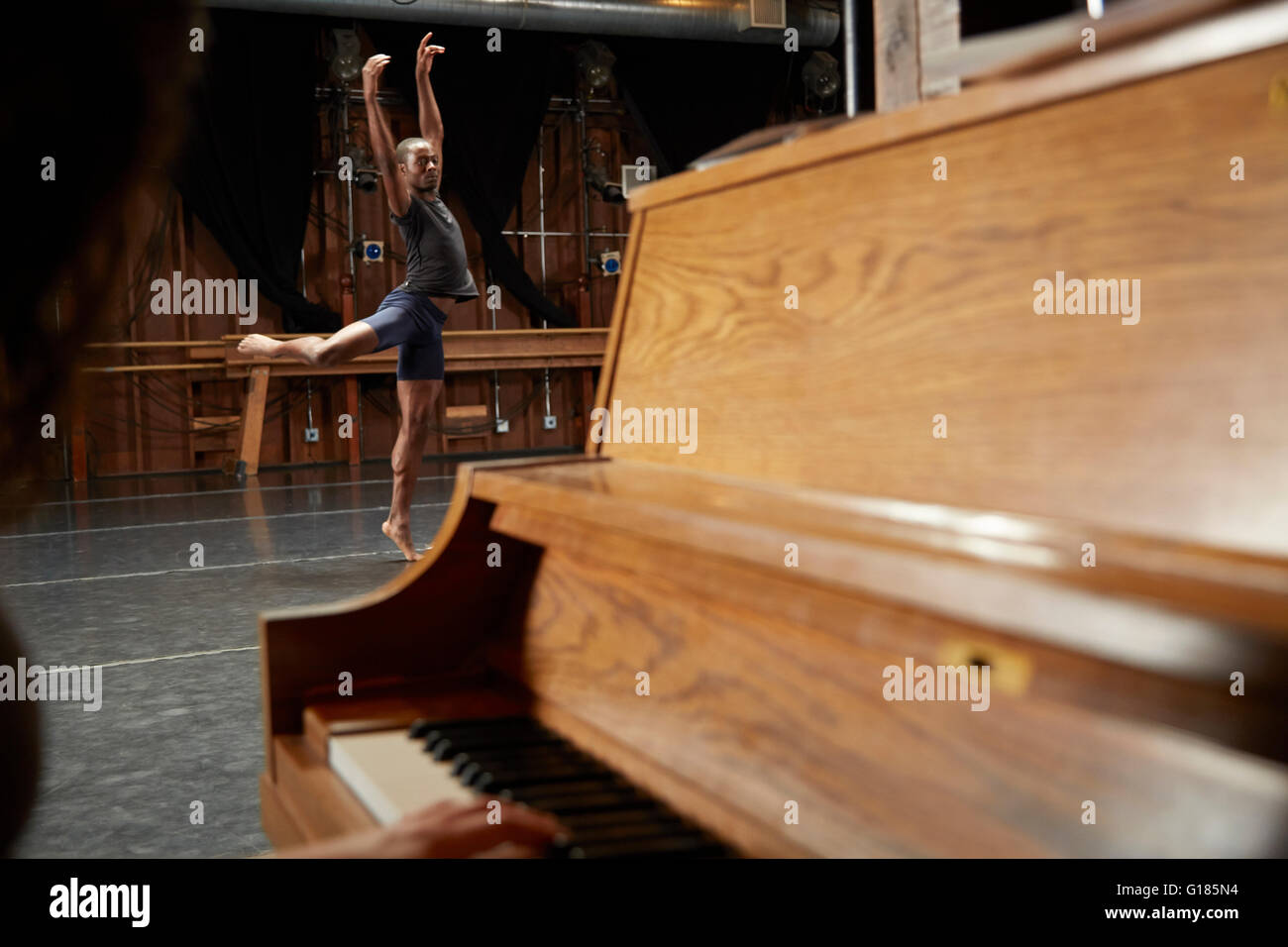 Ballet dancer in position, piano in foreground Stock Photo