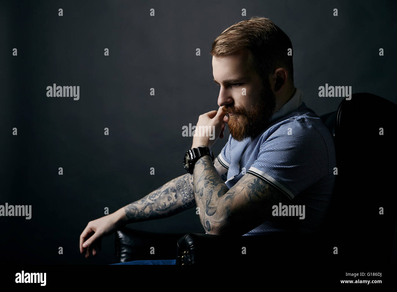 Thoughtful red bearded man studio portrait on dark background Stock Photo