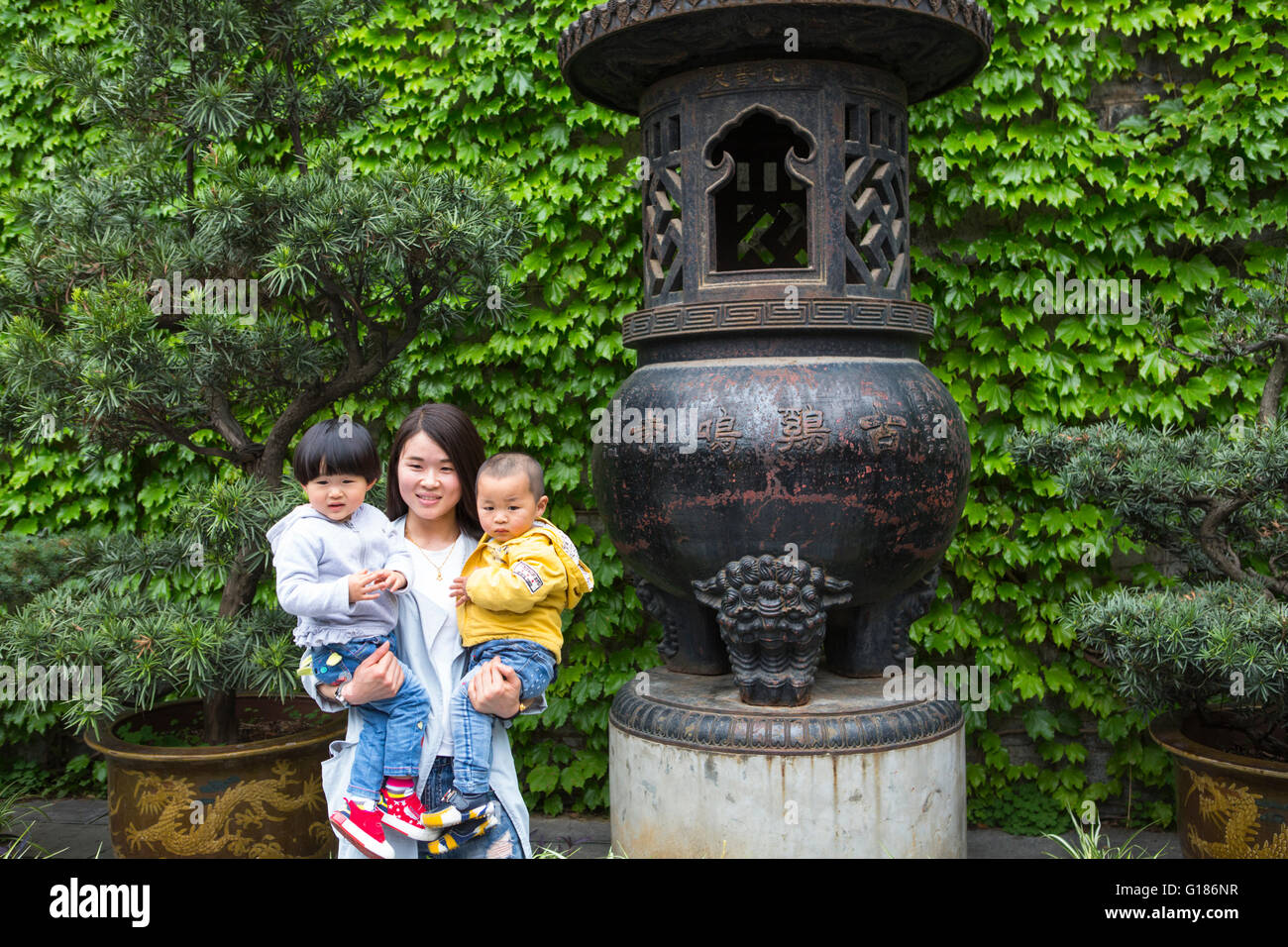 Proud Chinese mother posing with two children at the Jiming temple at Nanjing in China Stock Photo