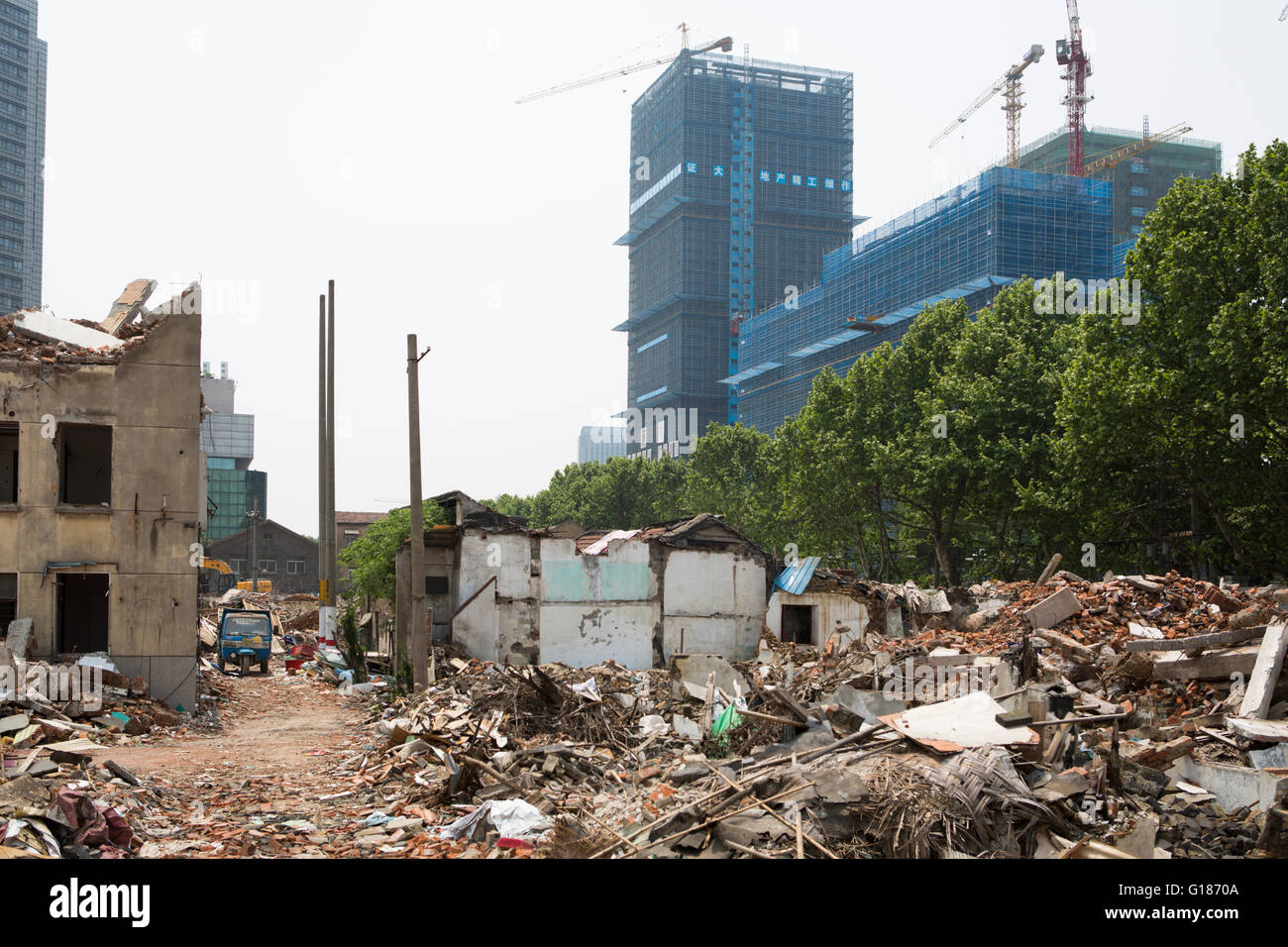 Demolished Chinese houses with debris on the ground, for new building urbanization activity, new construction with cranes background Stock Photo