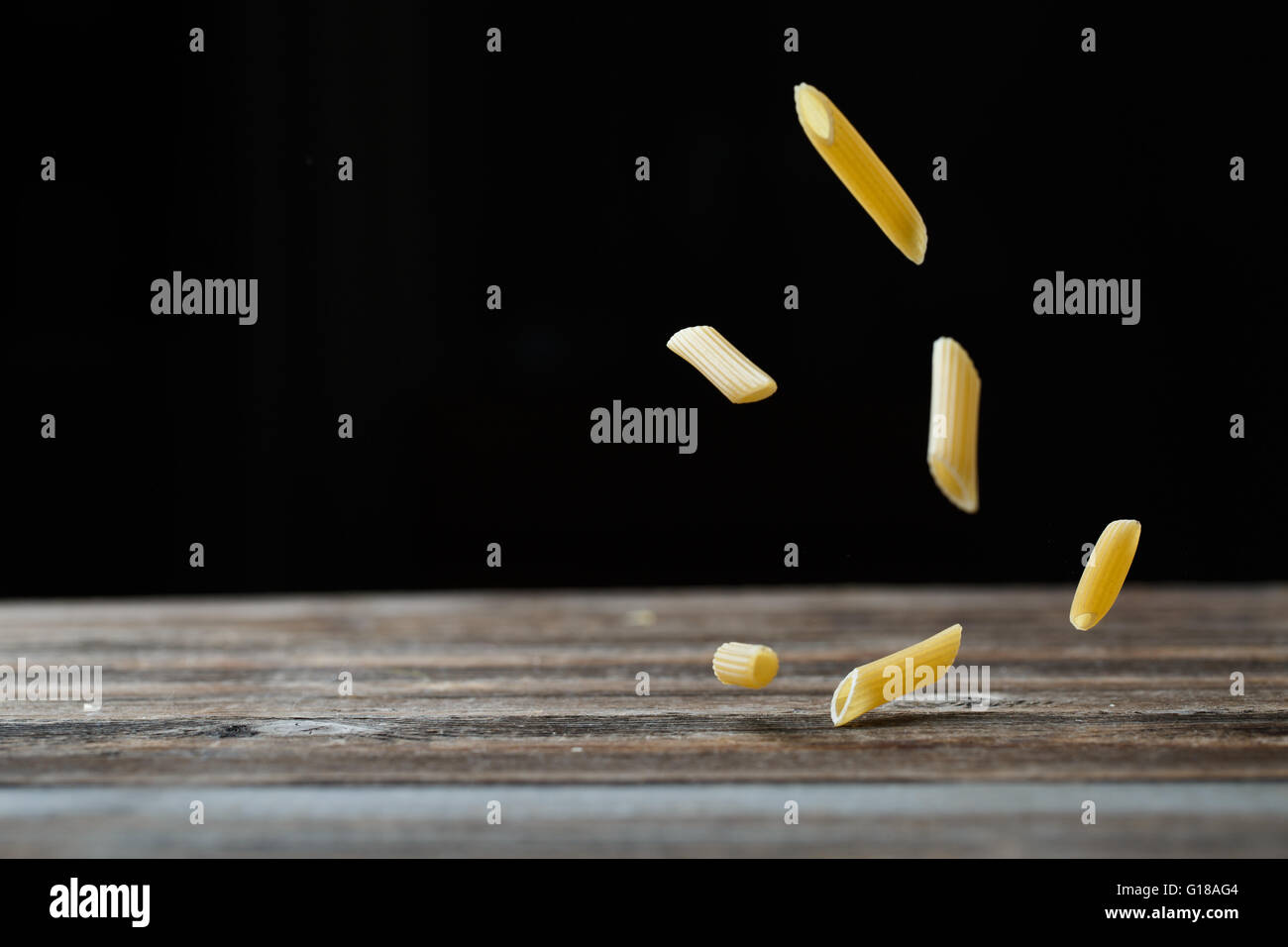 Download Falling Penne Pasta Flying Yellow Raw Macaroni Over Black Stock Photo Alamy PSD Mockup Templates
