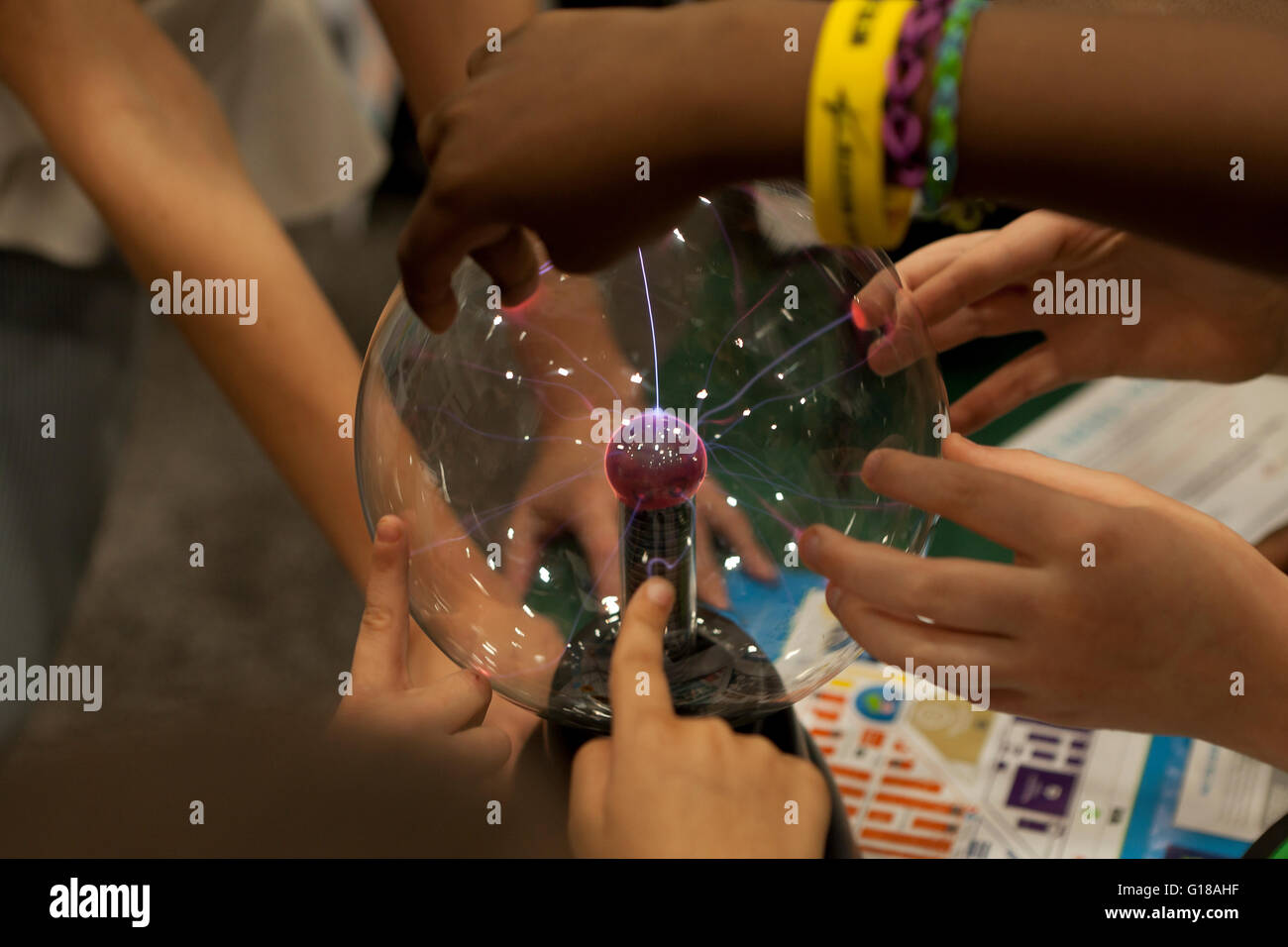 Children interacting with plasma globe at science fair - USA Stock Photo