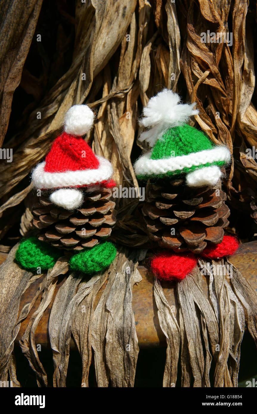 Christmas pine gnome, Xmas pinecone wear Xmas hat for decoration on winter holiday, with red, green yarn, homemade product Stock Photo