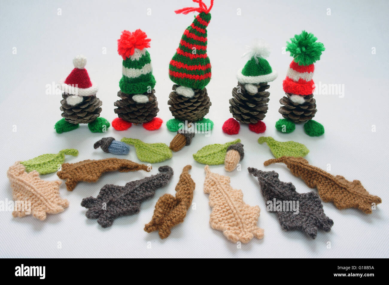 Christmas pine gnome on white background, Xmas pinecone wear Xmas hat for decoration on winter holiday, with red, green yarn Stock Photo