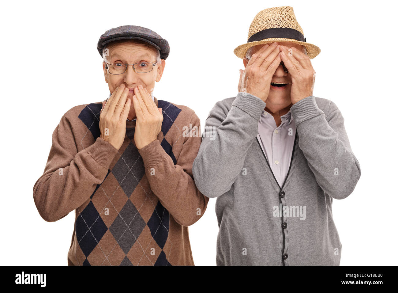 Two cheerful senior gentlemen covering their eyes and mouth isolated on white background Stock Photo