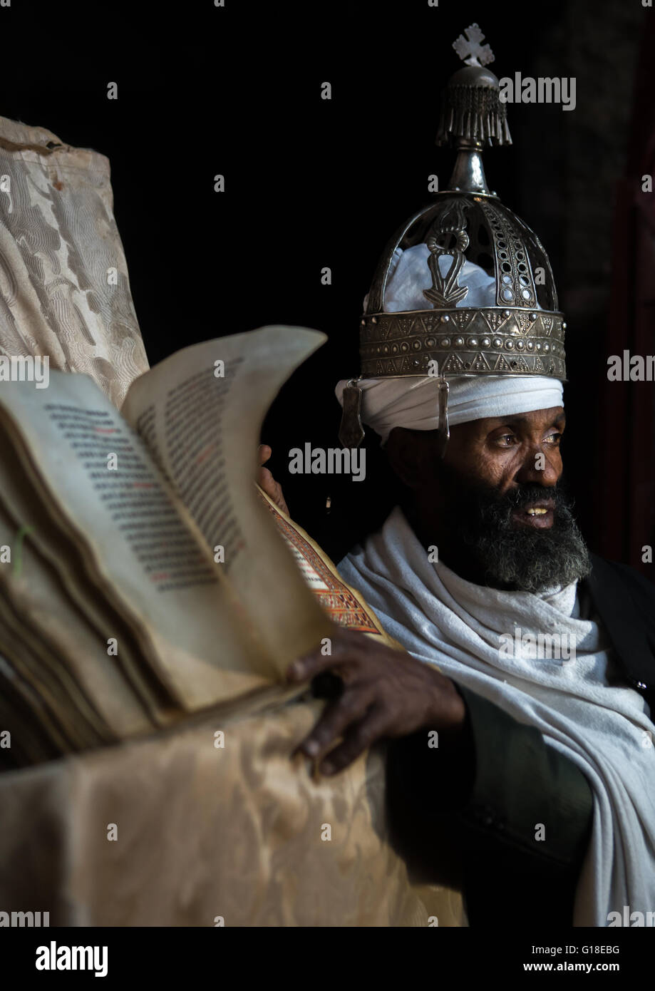 Ethiopian orthodox priest with an old bible in nakuto lab rock church, Amhara region, Lalibela, Ethiopia Stock Photo