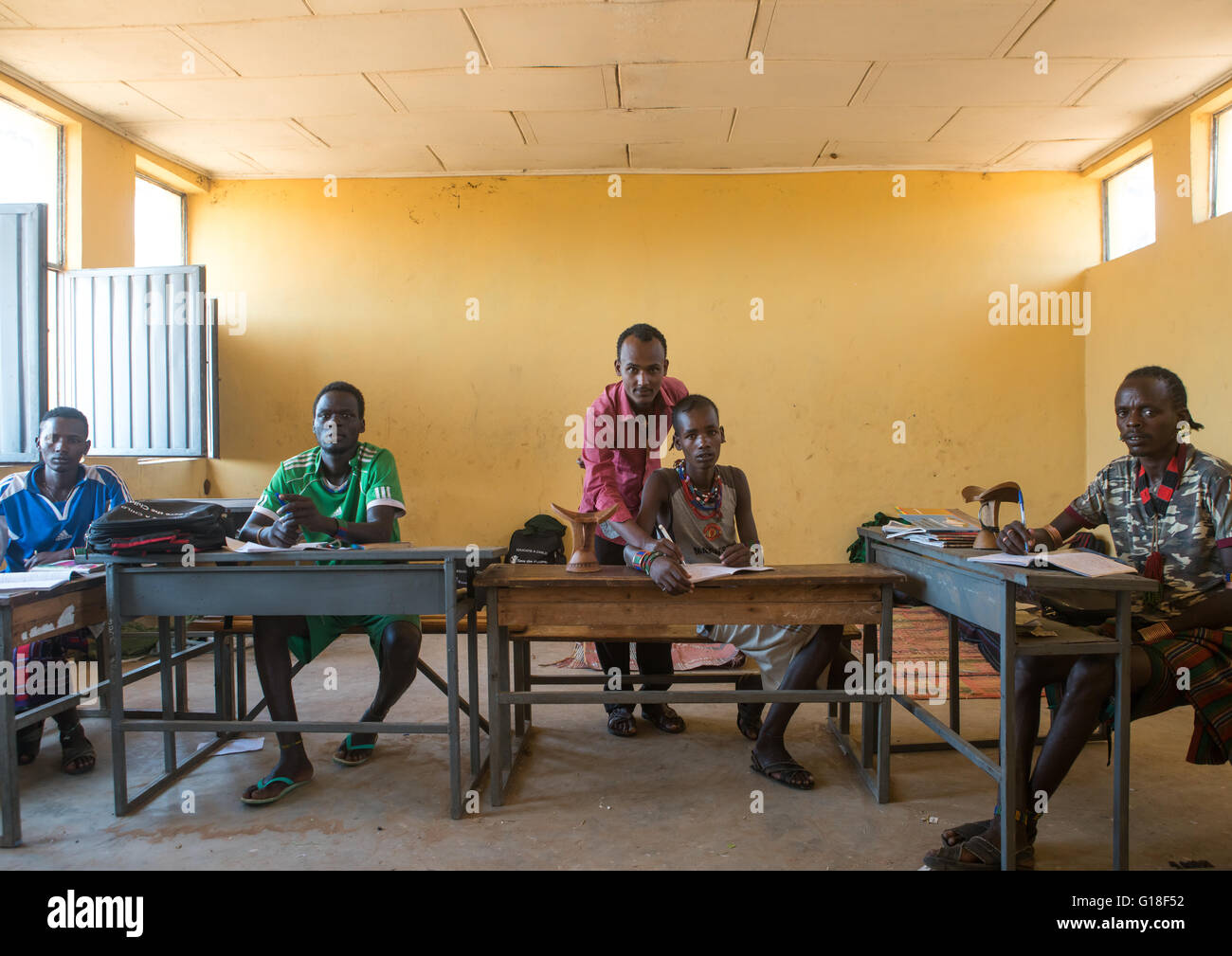 Hamer tribe teenage boys in classroom with their teacher, Omo valley, Turmi, Ethiopia Stock Photo