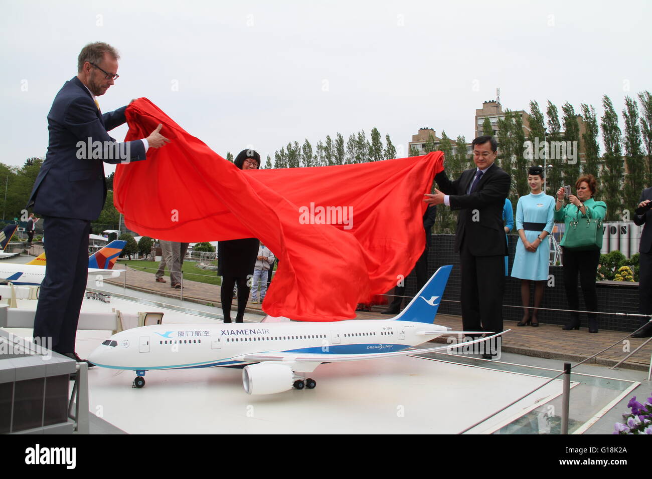 (160510) -- HAGUE, May 10, 2016 (Xinhua) -- Jos Vranken (L), director of the Netherlands Board of Tourism and Conventions (NBTC) and Li Fei (R), economic counsellor of the Chinese Embassy in the Netherlands, unveil the miniature plane of Xiamen Airlines in Madurodam in The Hague, the Netherlands, May 10, 2016. A miniature plane of China's Xiamen Airlines was revealed on Tuesday in Madurodam, one of the most famous Dutch tourist attractions located in The Hague, an event highlighting the great potential of both the Chinese tourist market for the Netherlands and the cooperation between Chinese a Stock Photo