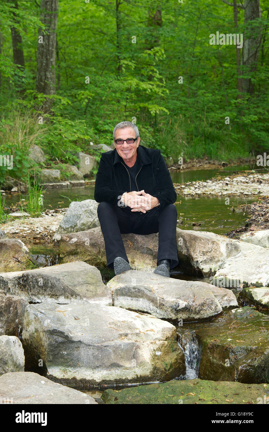 Seeshaupt, Germany. 10th May, 2016. dpa EXCLUSIVE - Tico Torres, drummer of Bon Jovi, sits between rocks after a presentation of his 'Rock Star Baby' fashion collection at the Lupaco Concept Store in Seeshaupt, Germany, 10 May 2016. Photo: Ursula Dueren/dpa/Alamy Live News Stock Photo