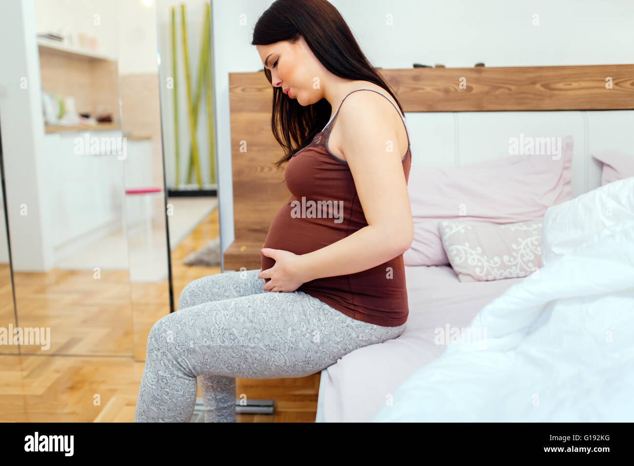 Pregnant woman having belly ache and cramps , spasms Stock Photo - Alamy
